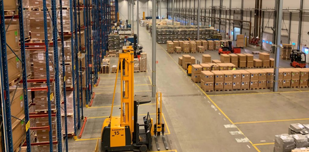 Organized warehouse with pallet storage and a forklift supporting freight distribution
